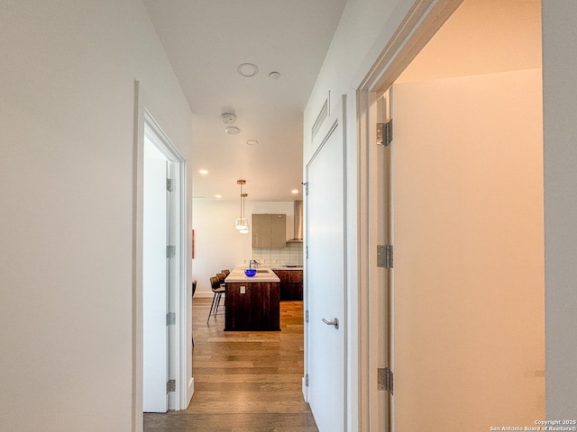 corridor featuring recessed lighting and wood finished floors