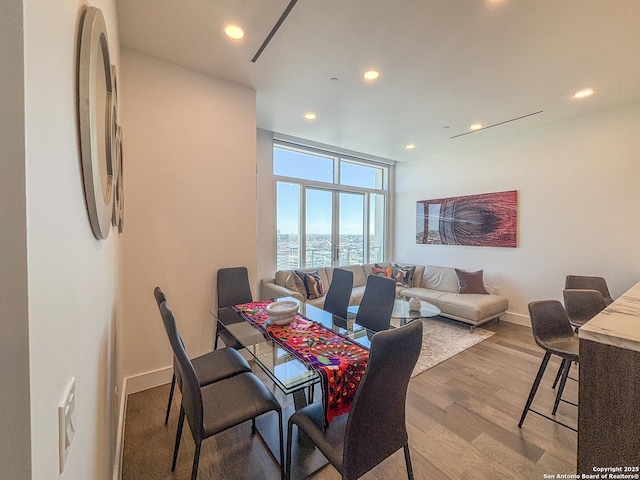 dining room with recessed lighting, light wood-style floors, and baseboards