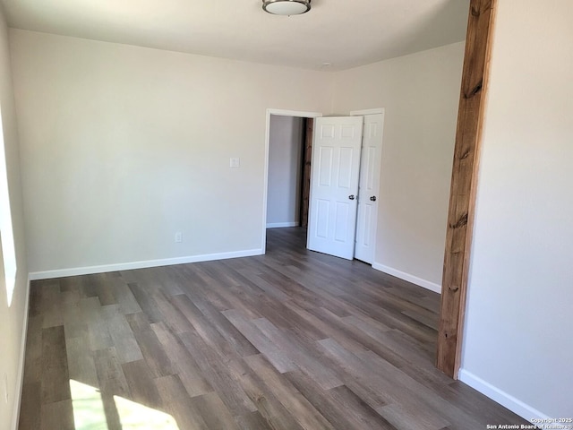 unfurnished bedroom featuring dark wood finished floors and baseboards