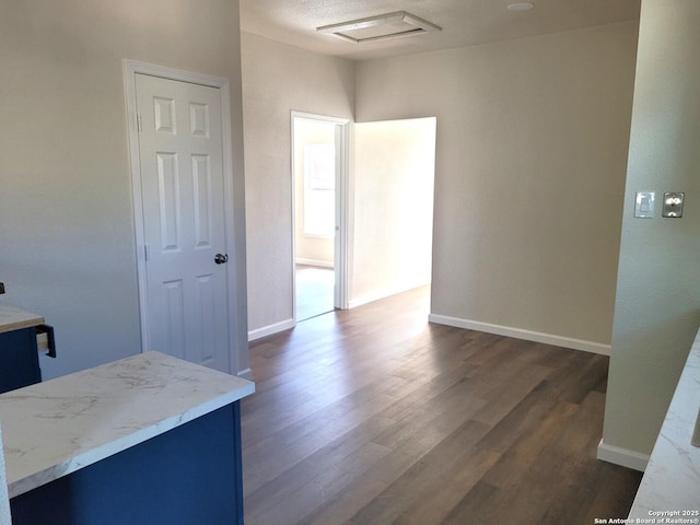 interior space featuring baseboards and dark wood-type flooring