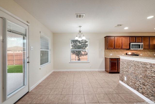 kitchen featuring visible vents, an inviting chandelier, decorative backsplash, appliances with stainless steel finishes, and pendant lighting