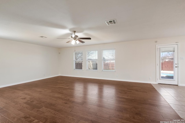 unfurnished room with visible vents, baseboards, and wood finished floors