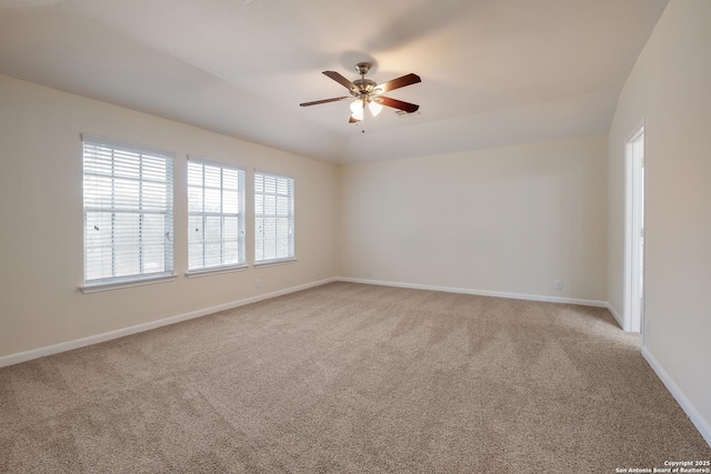 carpeted empty room with a ceiling fan and baseboards