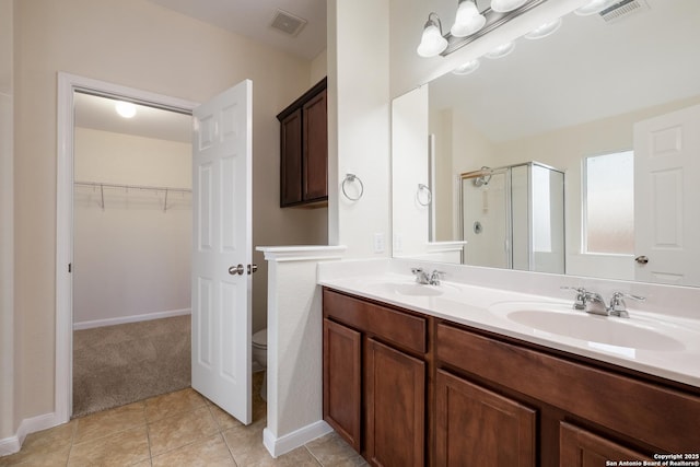 bathroom featuring visible vents, a shower stall, and a sink