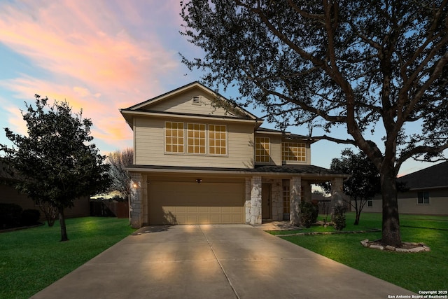 traditional-style house with stone siding, a lawn, driveway, and a garage