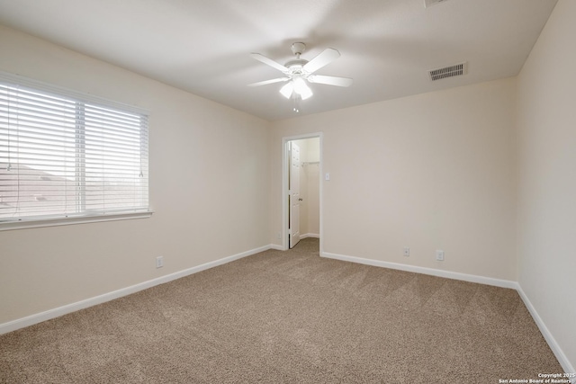 unfurnished room featuring visible vents, baseboards, light colored carpet, and ceiling fan