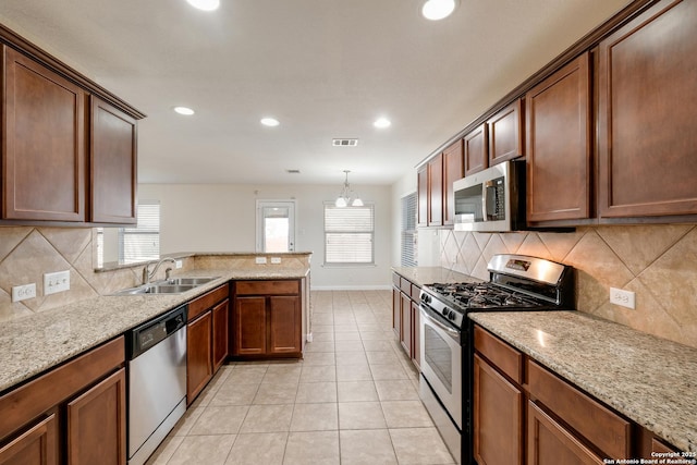 kitchen with visible vents, light stone counters, light tile patterned flooring, stainless steel appliances, and a sink