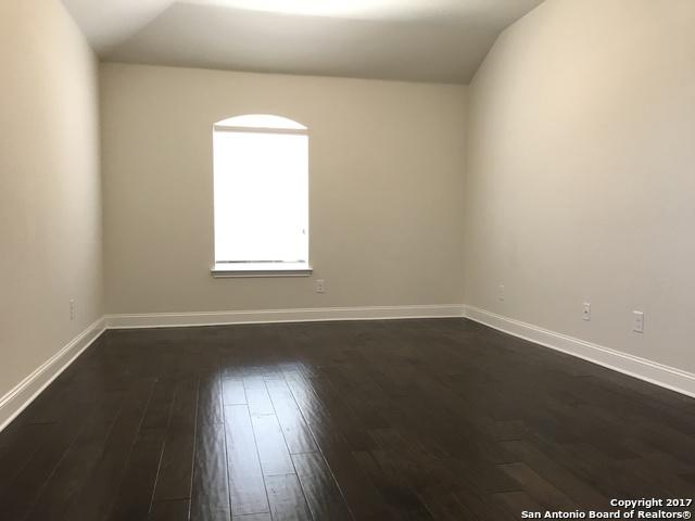 spare room featuring baseboards and dark wood-style flooring