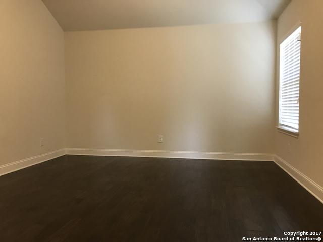 spare room with baseboards and dark wood-style flooring