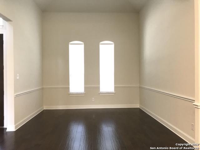 spare room with baseboards and dark wood finished floors