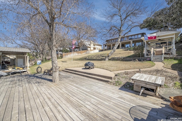 deck featuring a yard, fence, and an outdoor fire pit