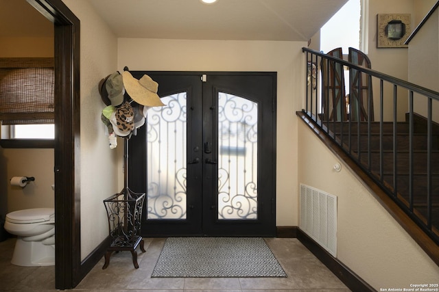 entryway with visible vents, baseboards, stairs, and french doors