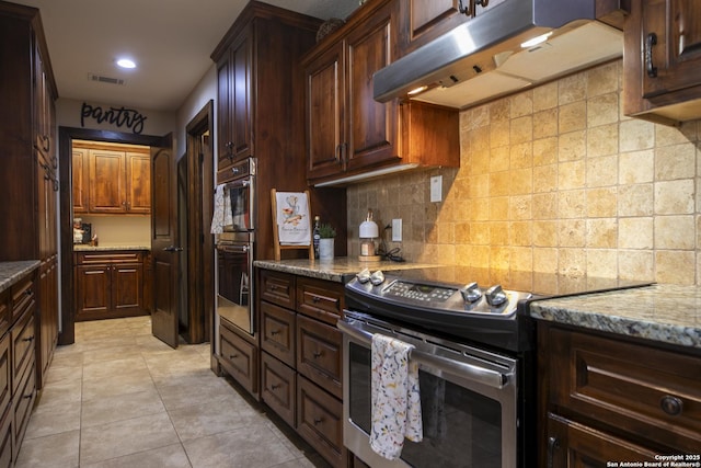 kitchen with visible vents, under cabinet range hood, stainless steel appliances, light tile patterned flooring, and decorative backsplash