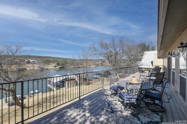 wooden deck with an outdoor fire pit and a water view