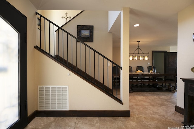 staircase featuring visible vents, recessed lighting, baseboards, and an inviting chandelier