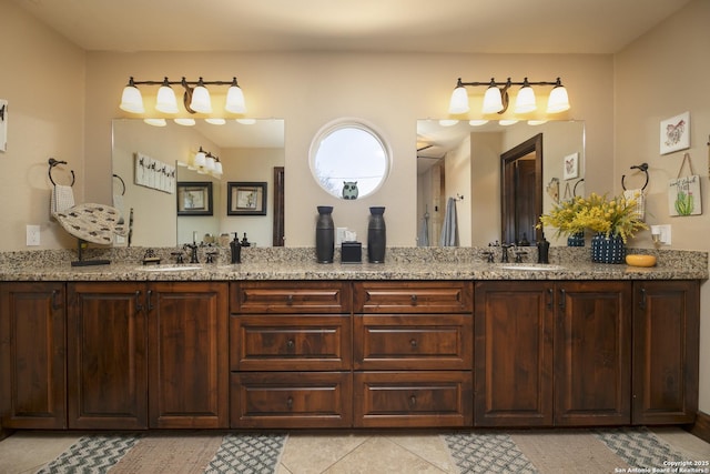 full bathroom with double vanity, tile patterned floors, and a sink