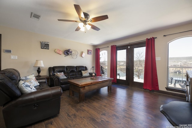 living area with visible vents, ceiling fan, and wood finished floors