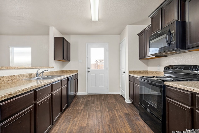 kitchen with a sink, dark brown cabinetry, black appliances, and dark wood-style flooring