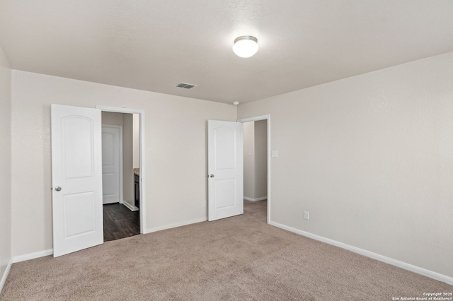 unfurnished bedroom with visible vents, baseboards, and carpet