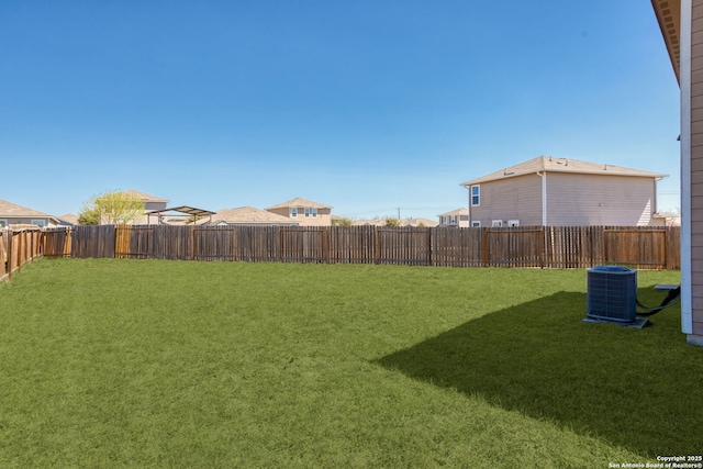 view of yard with central AC unit and a fenced backyard