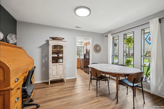 dining room with baseboards, visible vents, and light wood-type flooring