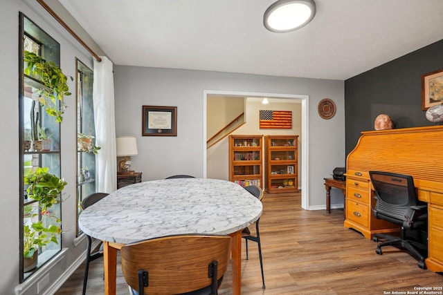 dining room featuring wood finished floors and baseboards