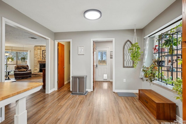 corridor featuring baseboards and light wood-style flooring