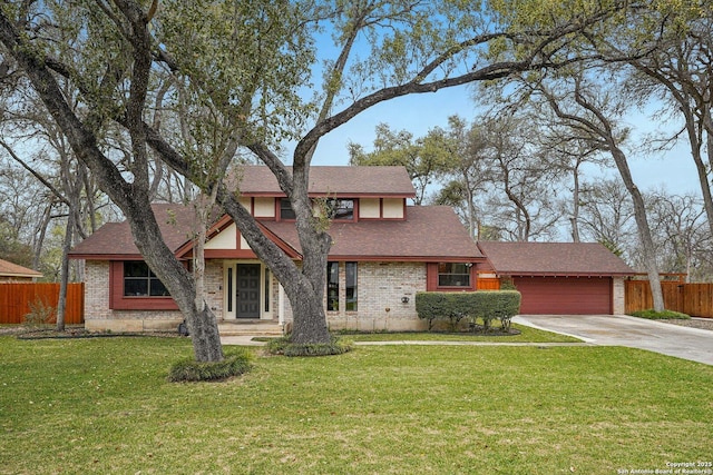 view of front of house with a front yard, fence, driveway, a garage, and brick siding