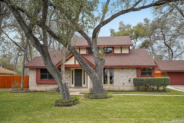 view of front of property with a front lawn, fence, and brick siding