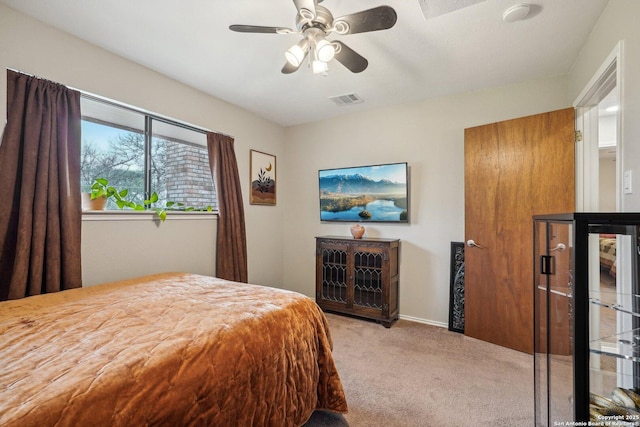 carpeted bedroom with a ceiling fan, visible vents, and baseboards