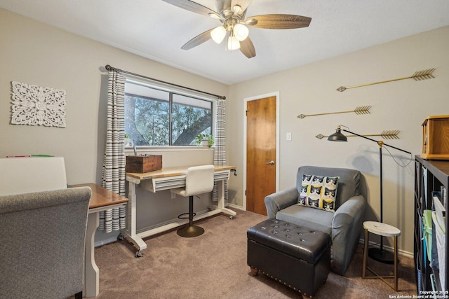 carpeted office space featuring baseboards and ceiling fan