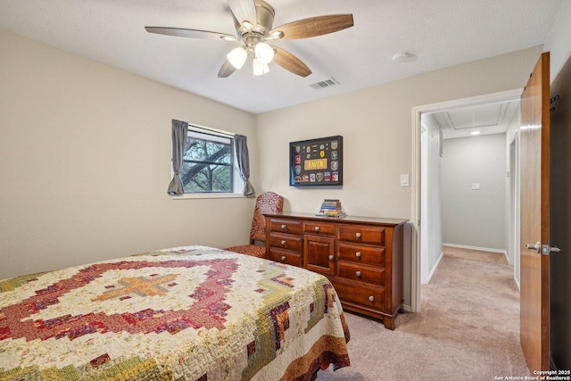 bedroom featuring visible vents, baseboards, attic access, light carpet, and a ceiling fan