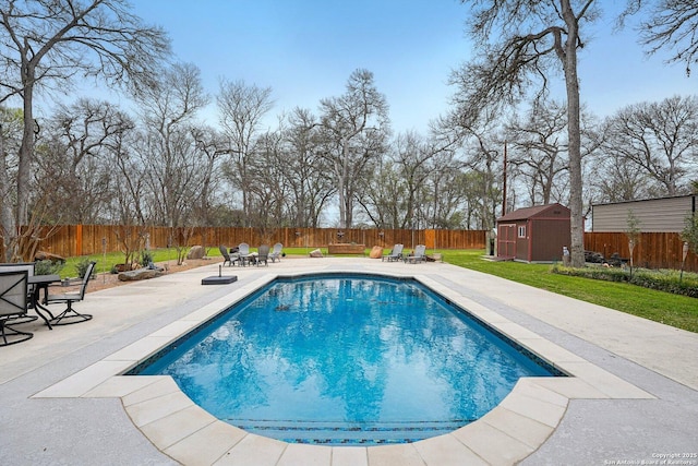 view of swimming pool featuring a fenced in pool, a fenced backyard, an outdoor structure, a yard, and a patio