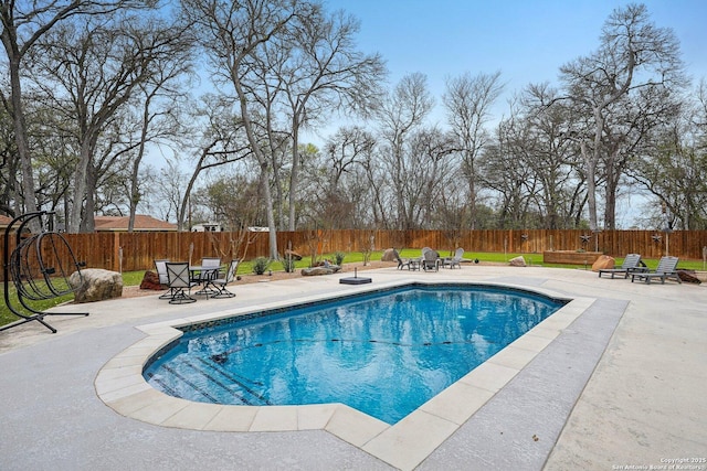 view of swimming pool featuring a fenced backyard, a fenced in pool, a fire pit, and a patio