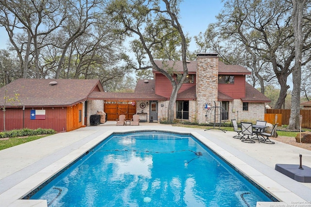 view of swimming pool with a patio, a fenced in pool, and fence