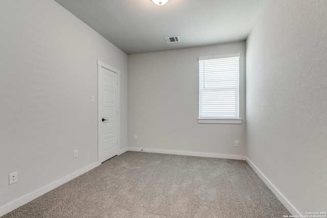 carpeted empty room with visible vents and baseboards