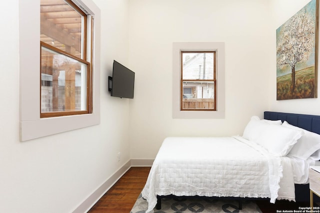 bedroom with dark wood finished floors and baseboards