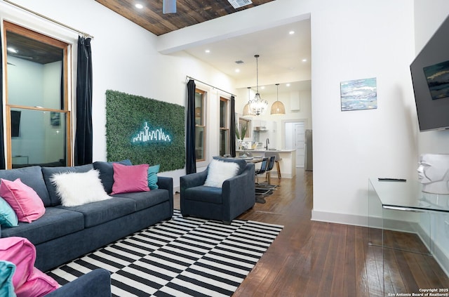 living room with visible vents, beam ceiling, hardwood / wood-style floors, recessed lighting, and baseboards