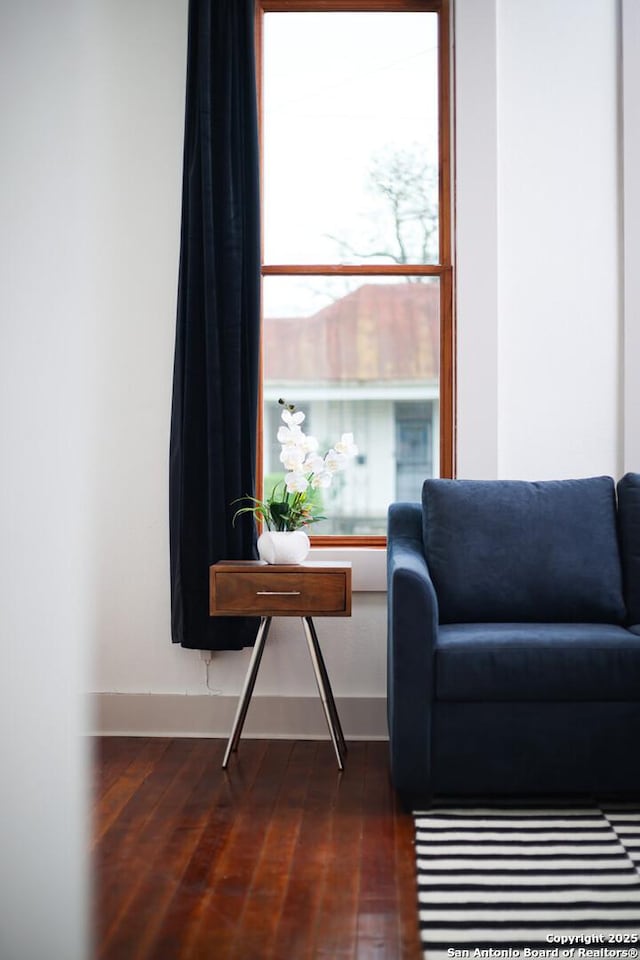 living area featuring baseboards and dark wood-style flooring