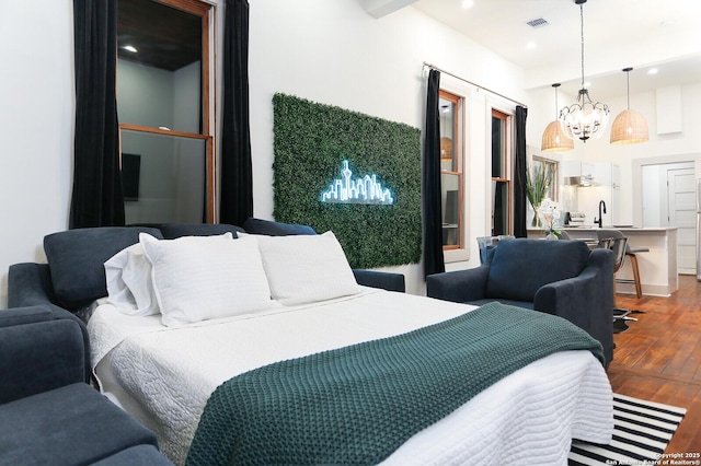 bedroom featuring visible vents, dark wood-type flooring, recessed lighting, a notable chandelier, and a sink