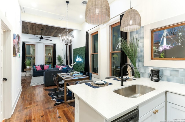 kitchen featuring visible vents, a sink, dark wood-type flooring, white cabinets, and pendant lighting