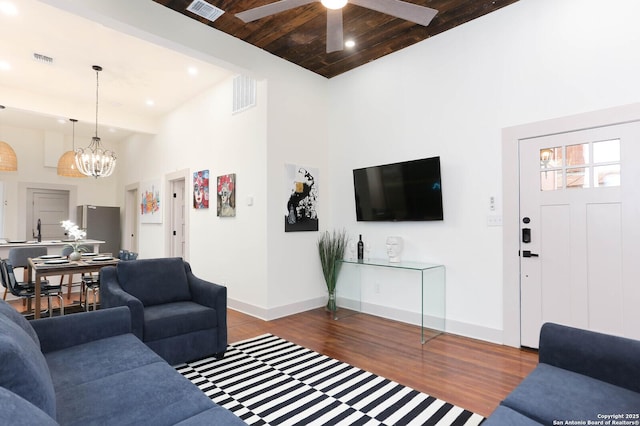 living room featuring visible vents, baseboards, and wood finished floors