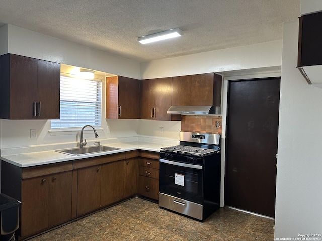 kitchen with stainless steel gas range, a sink, extractor fan, light countertops, and a textured ceiling