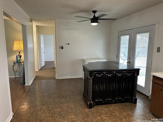 kitchen featuring a textured ceiling, dark cabinets, french doors, baseboards, and ceiling fan