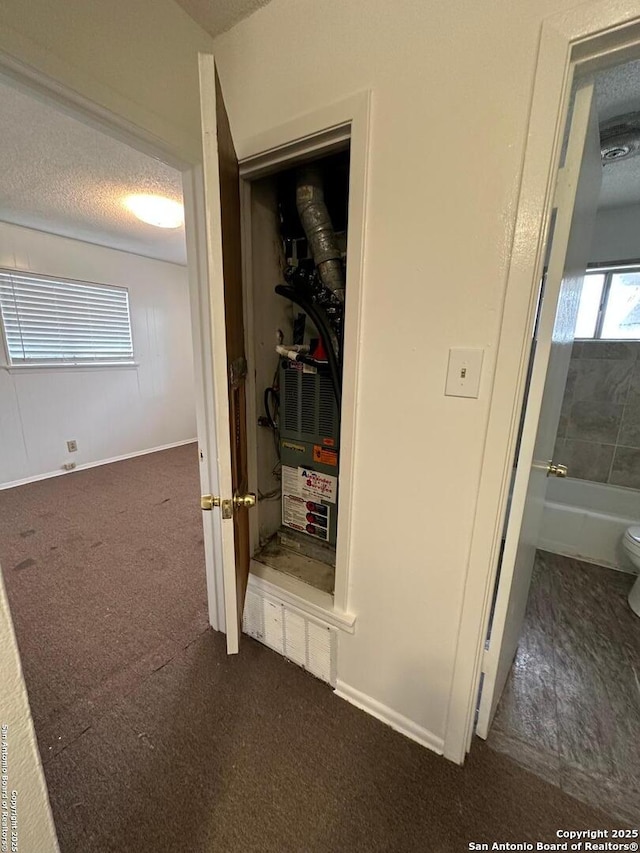 hall featuring carpet flooring, a textured ceiling, and baseboards