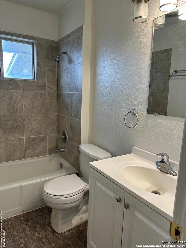 full bath with toilet, vanity, bathtub / shower combination, and a textured wall