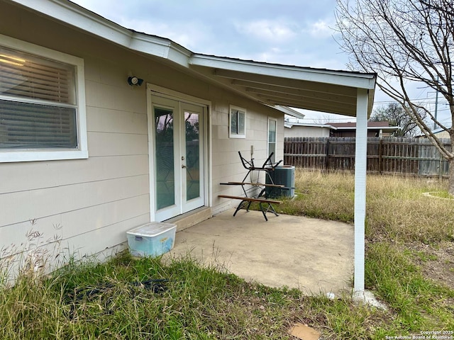 view of patio / terrace featuring french doors, central AC unit, and fence