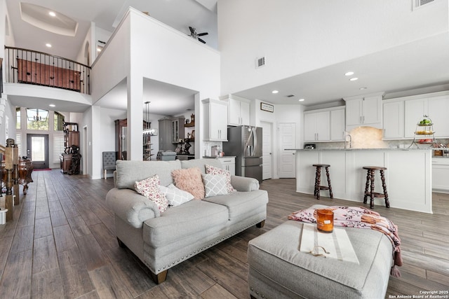 living area with dark wood-type flooring, recessed lighting, a ceiling fan, and visible vents