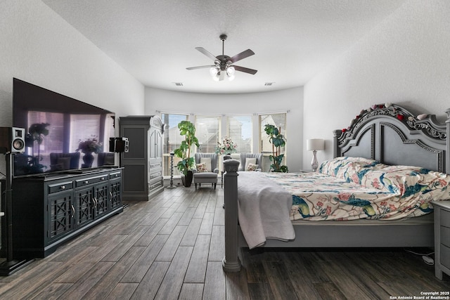 bedroom with a ceiling fan, wood finished floors, visible vents, and a textured ceiling