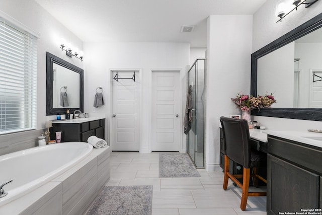 bathroom featuring vanity, a shower stall, a bath, and plenty of natural light